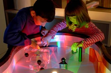 Visitors using a light table at the Science Museum