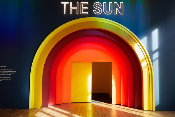 brightly painted yellow orange and red semicircular door to the sun exhibition