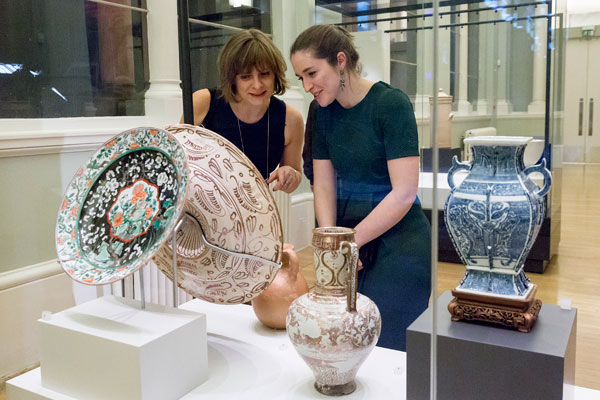 two women surrounded by large ornamental ceramics