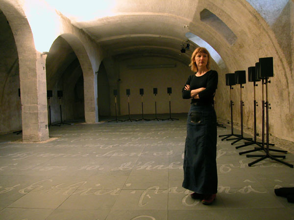 woman stands in valut with writing on the floor