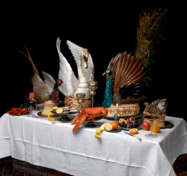 model showing pheasant and lobster among other extravagant foods on white tablecloth