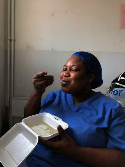 Woman eats her lunch in NHS uniform