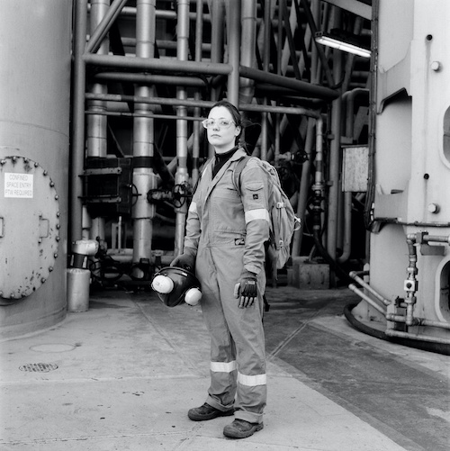 woman in overalls in sea industrial setting