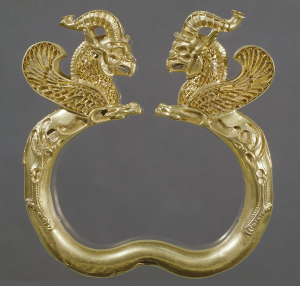 gold armlet featuring animals with wings and horns