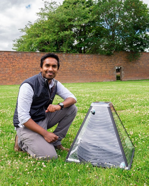 man sits near tree in garden with pyramid shaped new technology for tackling climate change