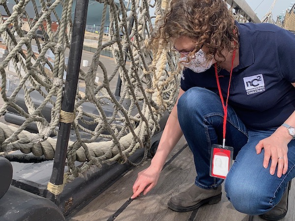 woman examines deck next to ropework