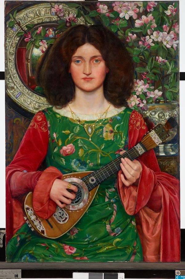 An oil painting rich in colour with vibrant greens and red. A young woman faces outwards she is shown from head to below waist. She has brown hair down to her shoulders and wears a green and red dress. In the top right corner are pink and white flowers with green foliage and behind the woman is a round mirror. The young woman holds a lute. 